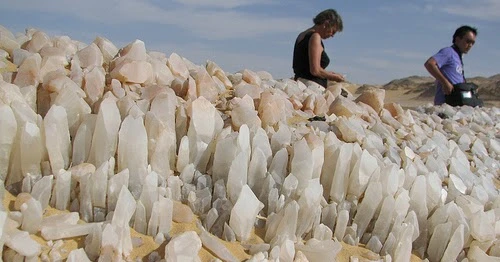 Travelers exploring the sparkling quartz formations of Crystal Mountain in Egypt’s desert near Bahariya Oasis.