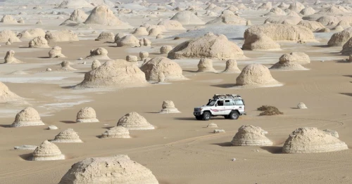 Traveler taking photos at Egypt’s White Desert with surreal rock formations and golden sunset