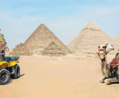 Essential packing items for desert trips in Egypt including hat, backpack, water bottle, and camera on sand background.